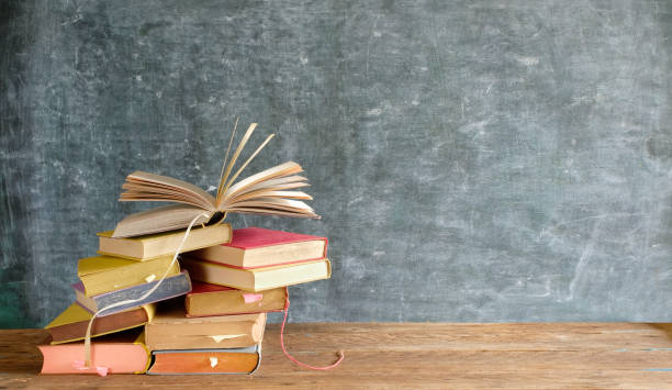 istock Stack of books in front of a blackboard.Back to school, reading, education,library concept 1269308237