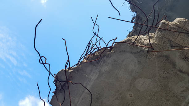 istock Destruction of a concrete structure with reinforcement against a blue sky background. Old concrete floor of an abandoned building 1269309328