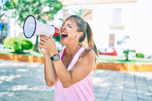 istock Middle age sportswoman screaming using megaphone at the park 1269311293