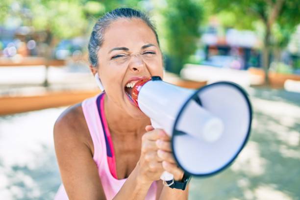 istock Middle age sportswoman screaming using megaphone at the park 1269311294