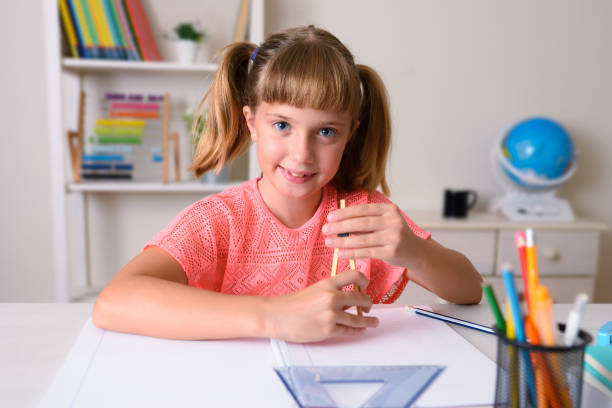 garota sorridente fazendo trabalho de classe com uma bússola em casa - school supplies pencil colors apartment - fotografias e filmes do acervo