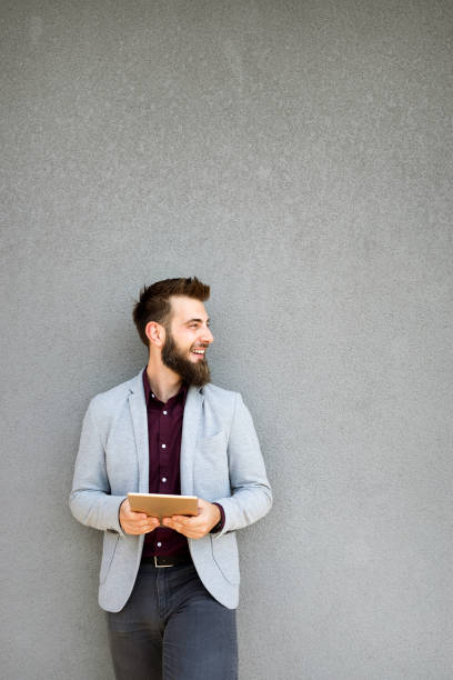 istock Happy young business male executive using digital tablet against gray background 1269314888