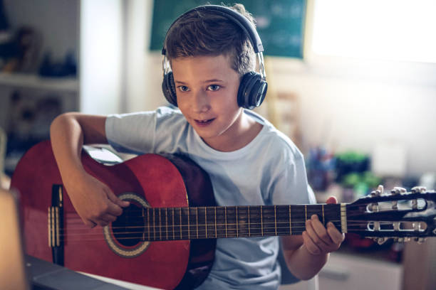 istock COVID 19 little boy  playing guitar in his room 1269315536