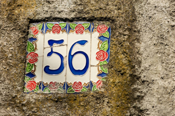 House Number 56 on the wall - Liguria Italy Close-up of house number 56 (fifty six) on the wall in a small village. Liguria, Italy, Europe ceramic tile house numbers stock pictures, royalty-free photos & images