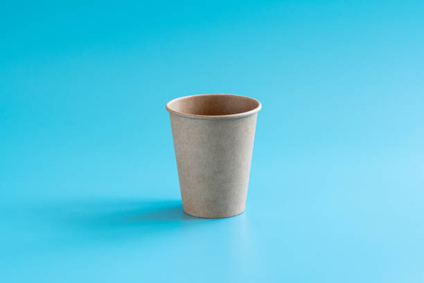 istock One disposable brown craft paper cup on blue background. Eco-friendly tableware. Minimal style. Recycling concept 1269322936