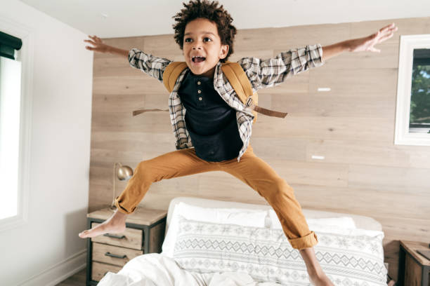 istock Boy jumping in his bedroom with backpack. He is ready for school 1269322972
