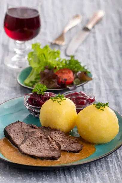 german sauerbraten on a plate with dumplings