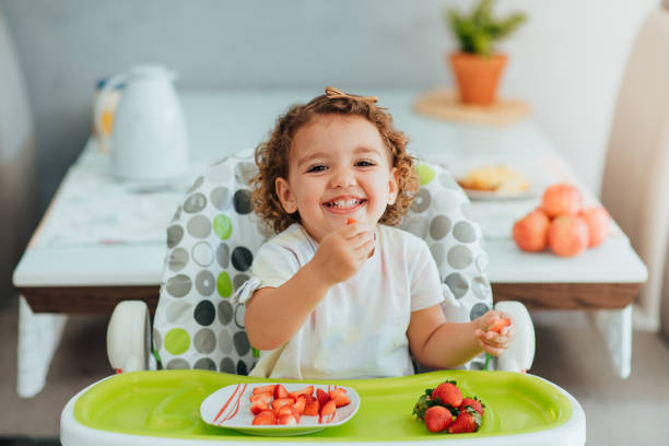 child eating strawberry for breakfast, healthy and vegan eating concept - criança de 1 a 2 anos imagens e fotografias de stock