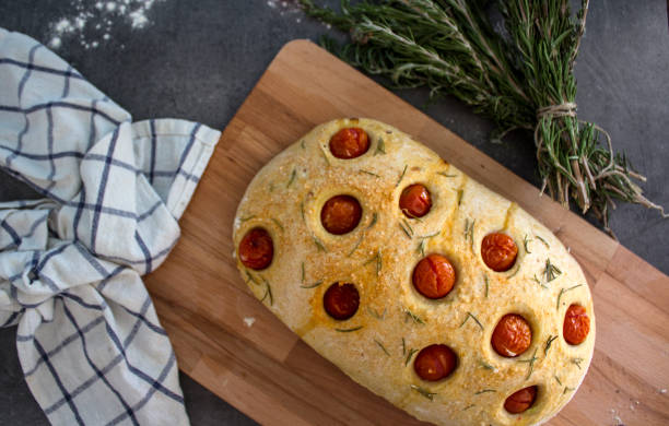 istock Foccacia bread with cherry tomatoes and rosemary on gray table 1269326627