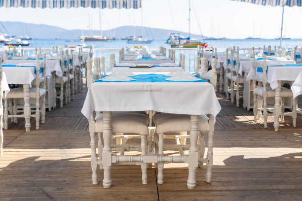 istock Elegant table setting with wine glass, white plate and blue napkin in restaurant . Nice dining table set with arranged silverware and napkins for dinner 1269328858