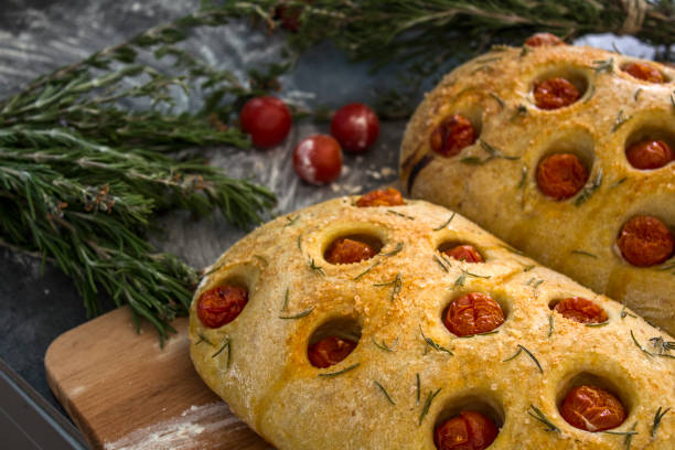 istock Foccacia bread with cherry tomatoes and rosemary on gray table 1269329082