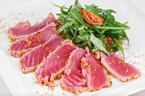 istock Sliced tuna fish grill with sesame seeds, tomatoes and arugula 1269329530