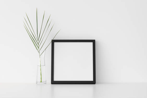 istock Black square frame mockup with palm leaf in a glass vase. 1269330578