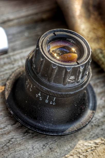 istock Old soviet microfilm enlarger lens / camera lens, close-up on wooden surface 1269332463