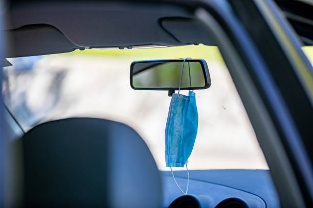 istock Surgical Mask Hanging on Rear-view Mirror in a Car 1269335633