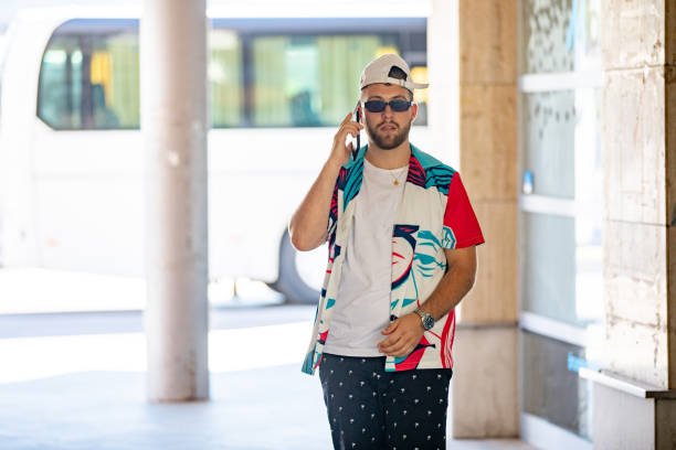 Young Adult Man Using Mobile Phone on Bus Station.