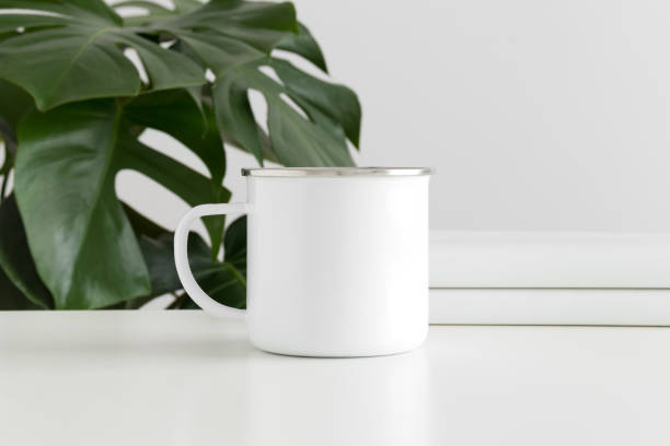 istock Enamel mug mockup with workspace accessories and a monstera plant. 1269335843