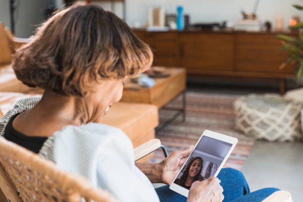 istock Unrecognizable grandmother smiles while chatting with granddaughter on digital tablet 1269341617