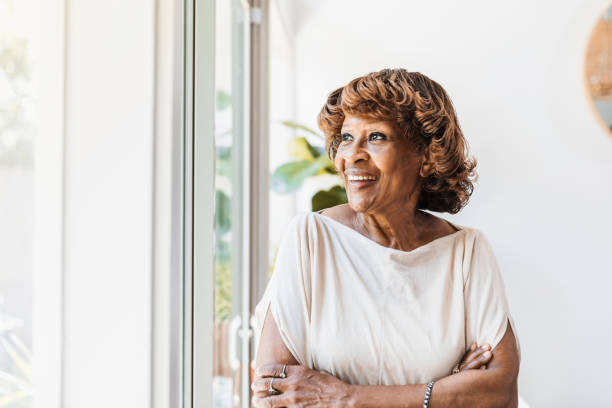istock Independent, confident senior woman smiles while looking out window 1269341626