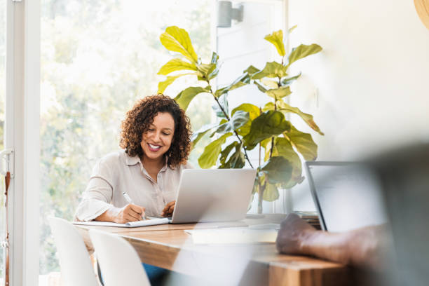 istock Woman smiles while working from home with unrecognizable husband 1269341634