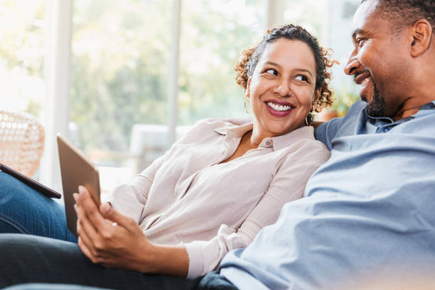 istock Wife smiles at husband while watching movie on digital tablet 1269341653