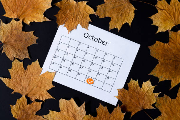 istock Halloween background. Calendar page with mark on October 31 and fall on dark table top view 1269343919