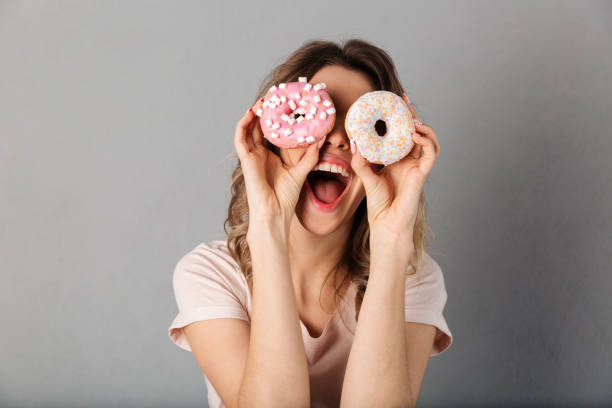 istock Woman in t-shirt having fun while holding donuts on eyes 1269346803