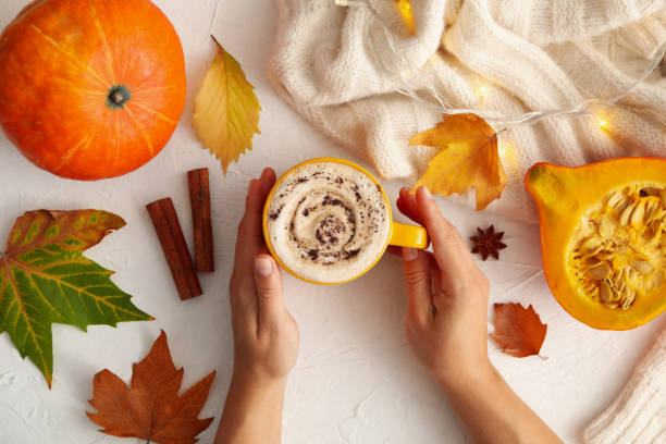 istock Composition with female hands hold pumpkin latte on white background 1269346816