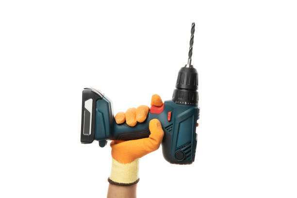 istock Male hand holds cordless drill, isolated on white background 1269350573