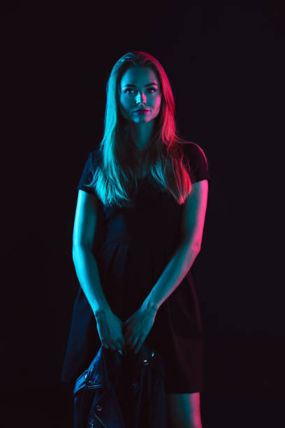 istock Caucasian woman's portrait isolated on dark studio background in neon light 1269351338