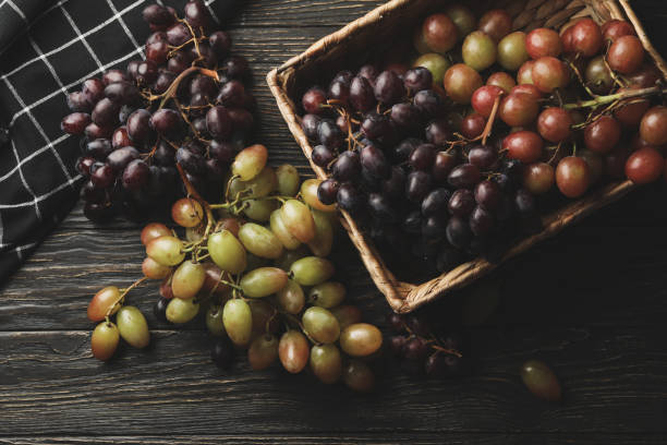 istock Napkin and basket with ripe grape on wooden background 1269352127