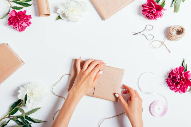 Top view of female hands wrapping presents