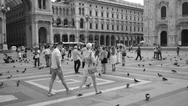 Milan, Italy - August 28, 2020: people visit, across, standing and take photo in the Duomo's square.