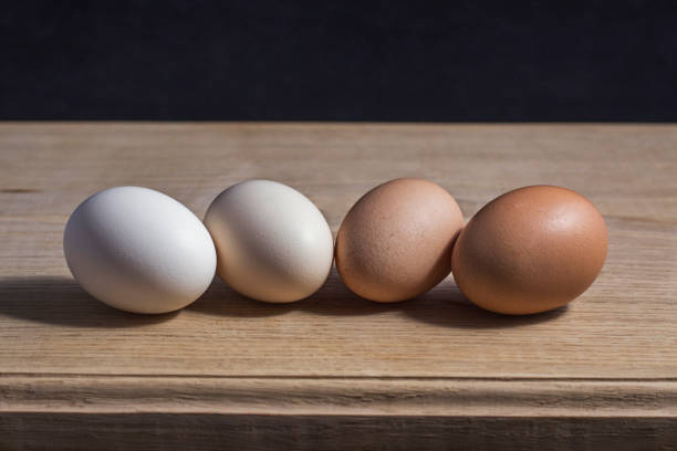 istock 4 eggs of different colors lie on a white oak kitchen board. 1269356703