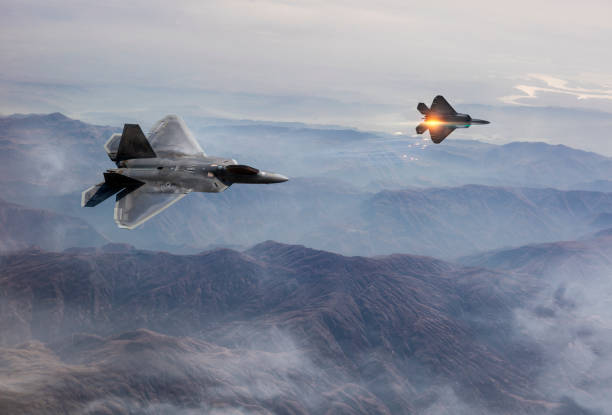 истребители f-22 пролетели над туманными горами - air raid стоковые фото и изображения