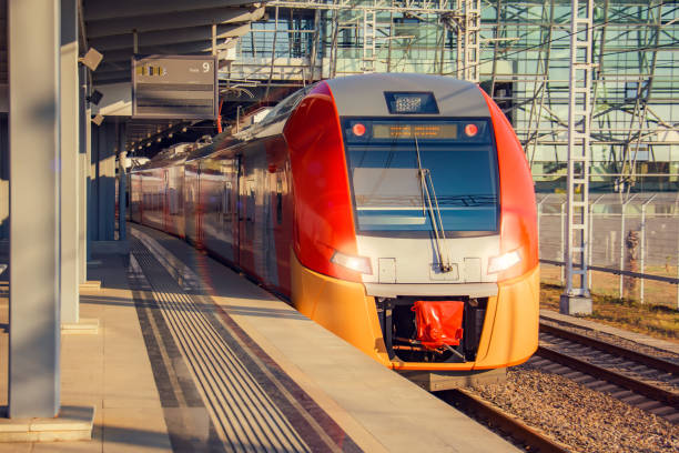 istock Suburban modern train at railway station at the stop of an empty passenger platform. 1269361495