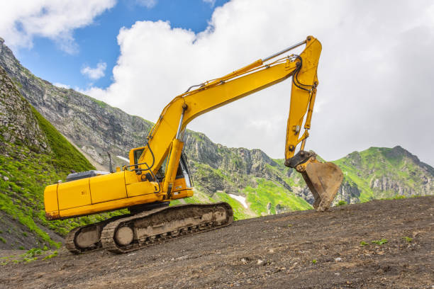 istock Excavator heavy equipment in mountains on steep range slopes. 1269361594