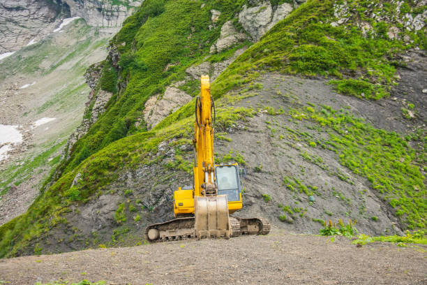 istock Excavator heavy equipment in mountains on steep range slopes. 1269361603
