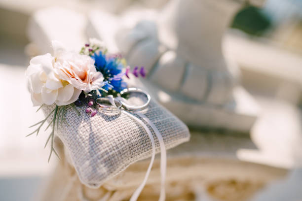 istock Wedding rings in white gold on a pillow with flowers. 1269362414