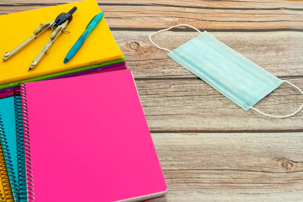 istock Return to school after the coronavirus. Notebooks, protective masks, pencils, calculator on a wooden table 1269362800