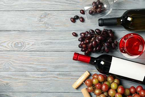 Composition with wine and grape on wooden background, space for text