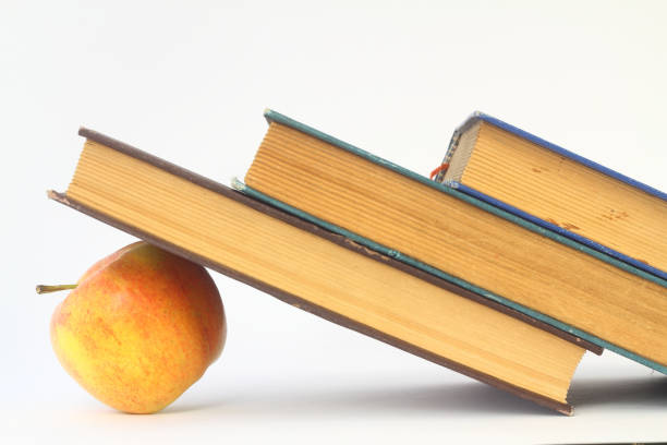 istock apple under a pile of books isolated on white background 1269366714