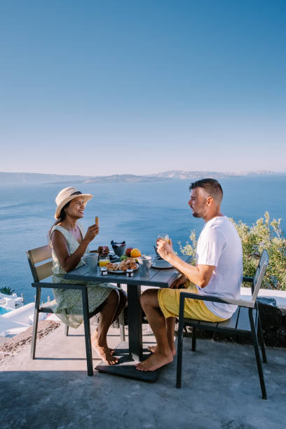 istock couple having breakfast at traditional cave house Santorini Greece, beautiful whitewashed village Oia with church and windmill during sunset 1269367991