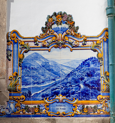Pinhão, Portugal 16/7/2020: The Pinhão Railway Station, on the Douro line, received the tile panels in 1937 that gave it notoriety and made it the most beautiful Douro Railway Station. In a total of about 3047 tiles, they were produced at Aleluia Cermicas (Fábrica Aleluia) by J. Oliveira. The 24 panels that cover almost all the walls of the main building represent the different stages of Port wine production, from the vintage when stepping on the grapes to transporting the wine in rabelo boats along the Douro River to the cellars in Vila Nova de Gaia .