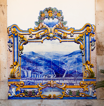 Pinhão, Portugal 16/7/2020: The Pinhão Railway Station, on the Douro line, received the tile panels in 1937 that gave it notoriety and made it the most beautiful Douro Railway Station. In a total of about 3047 tiles, they were produced at Aleluia Cermicas (Fábrica Aleluia) by J. Oliveira. The 24 panels that cover almost all the walls of the main building represent the different stages of Port wine production, from the vintage when stepping on the grapes to transporting the wine in rabelo boats along the Douro River to the cellars in Vila Nova de Gaia .