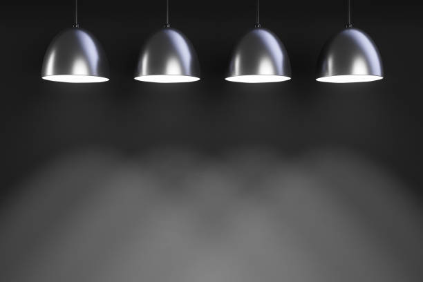 istock Four luminous pendant lights. Wall in background. 1269370538