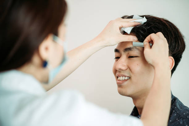 Asian chinese male getting eyebrow waxing at facial beauty salon close up shot using eyebrow knife trimming tool shaving eyebrow asian eyebrows stock pictures, royalty-free photos & images