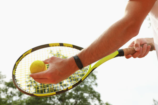 istock Man hold racket and tennis ball against sky 1269372901
