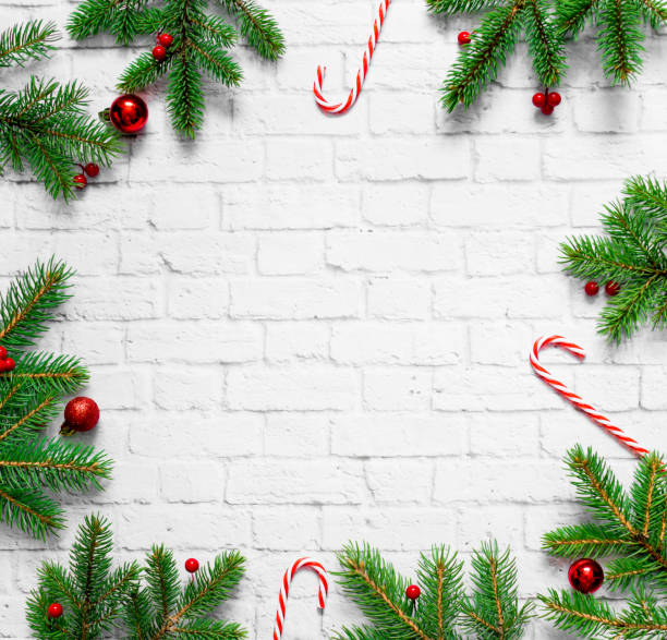 istock Christmas composition. Fir tree branches frame, sweet red canes, red Christmas balls on white concrete background. Christmas, winter, new year concept. Flat lay, top view, copy space 1269375591