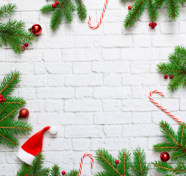 istock Christmas composition. Fir tree branches frame, sweet red canes, red Christmas balls on white concrete background. Christmas, winter, new year concept. Flat lay, top view, copy space 1269375607